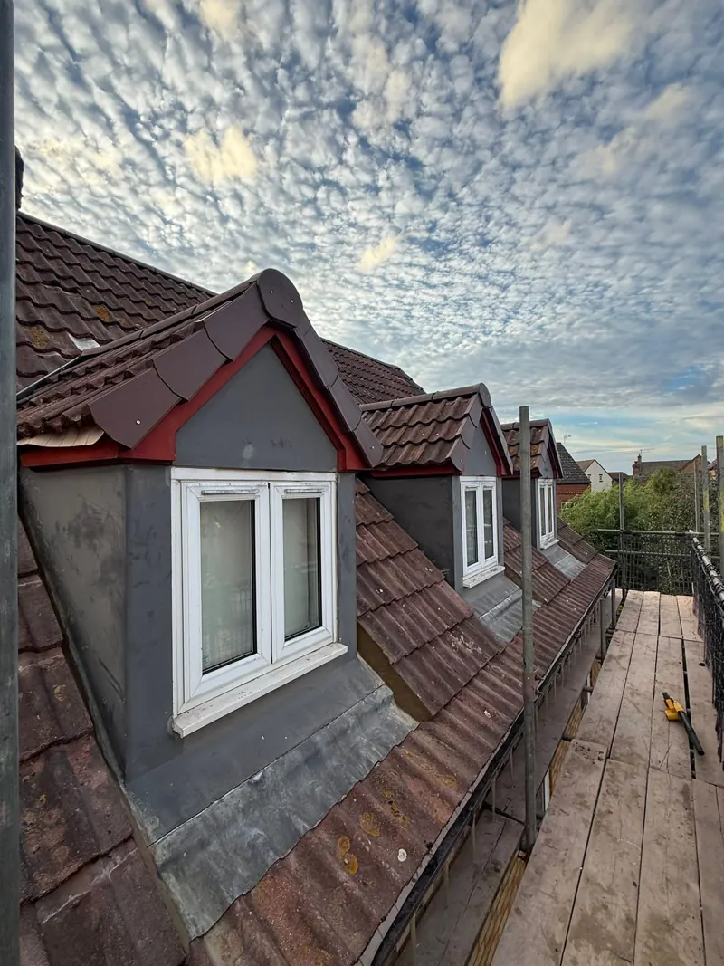 Close-up of one of the three front dormers with the old covering still in place before re-detailing